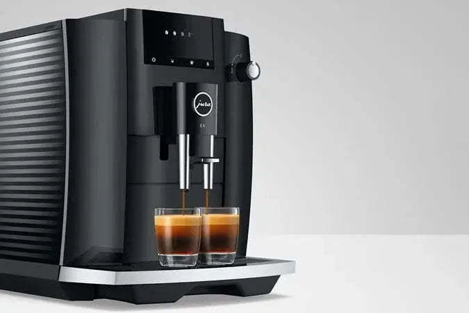 Jura E4 vs E6 volautomaat vergelijking met koffie en espresso in glazen.