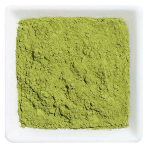 Pure matcha groene thee in een witte kom, fijn gemalen poeder met heldere groene kleur.