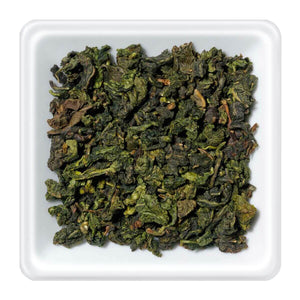 Milky oolong thee bladeren in een witte schaal, perfect voor een exquisite theebeleving.
