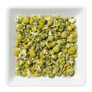 Biologische kamille thee in een witte schaal, ideaal voor een rustgevende infusie.